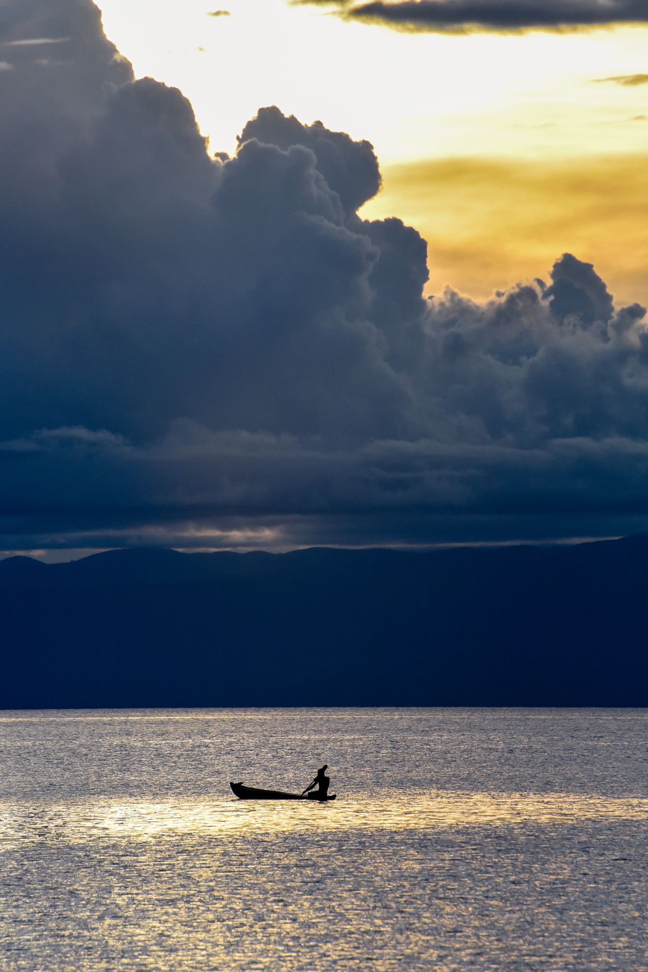 A canoe on the lake beneath towering storm clouds