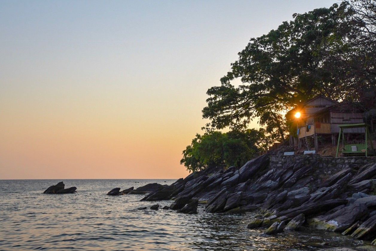 Rocky headland and lodge at sunset