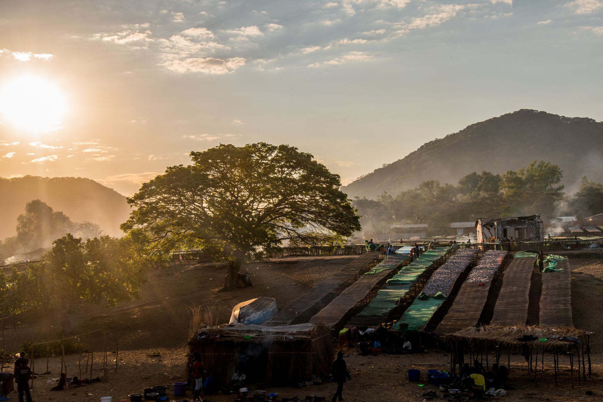 Lakeshore village and fish-drying racks in hazy sunlight